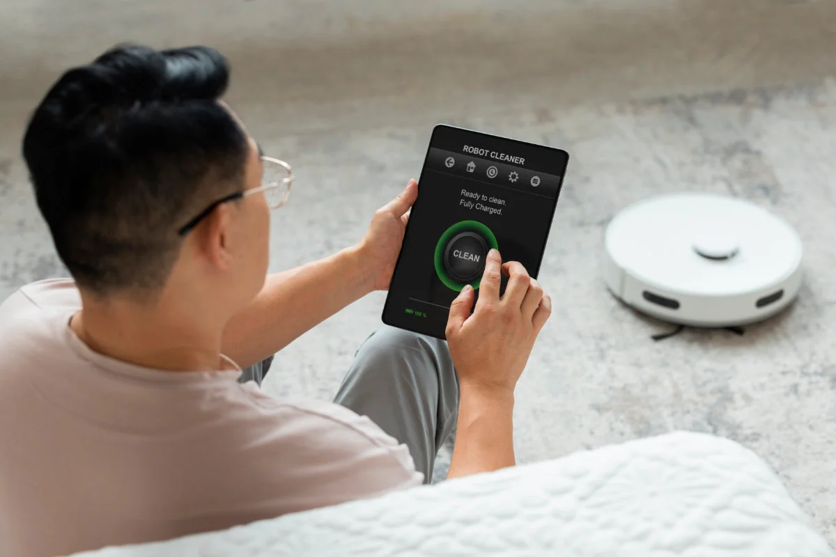 IOT-high-angle-man-with-robotic-vacuum-cleaner-home